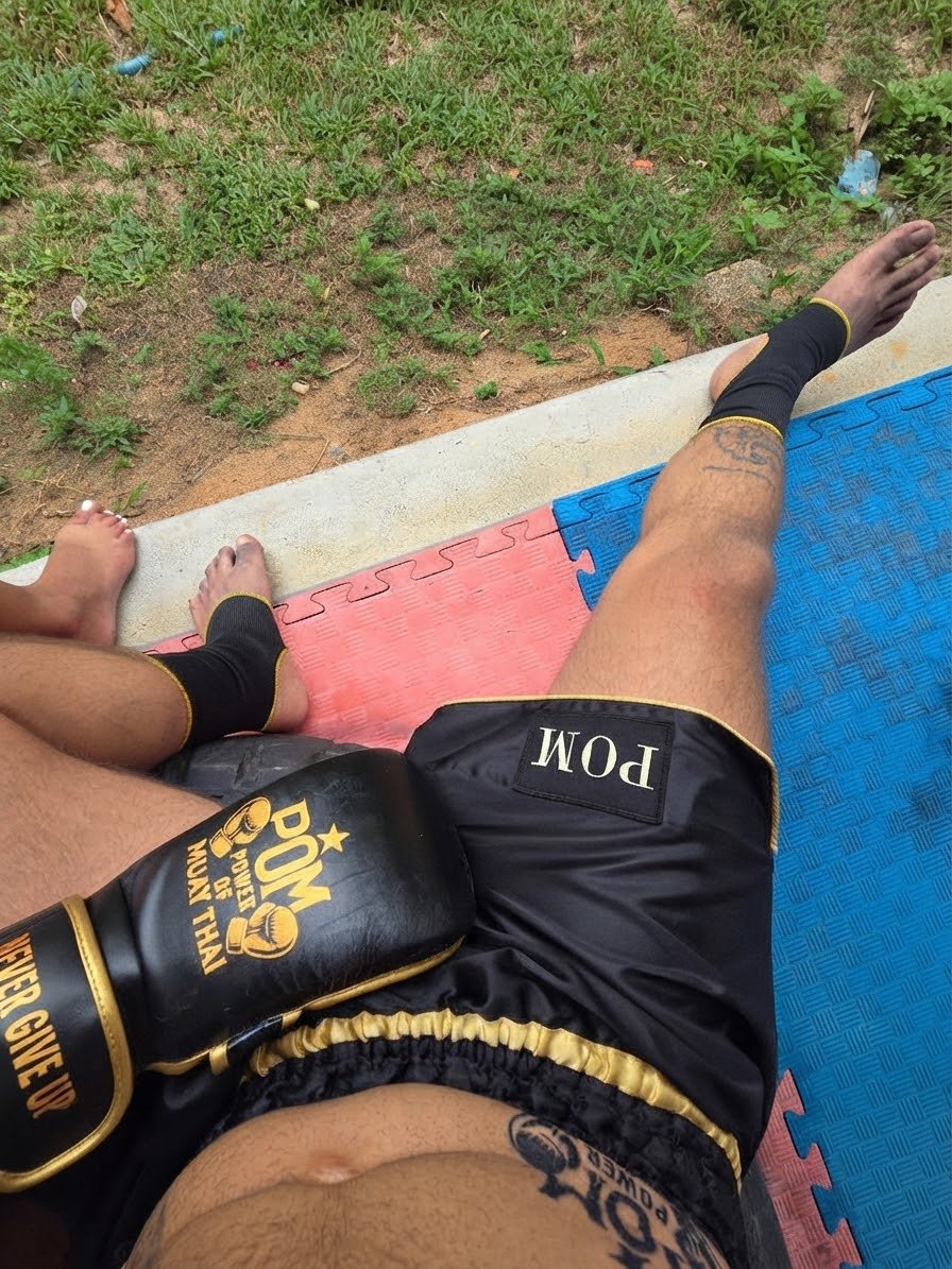 P.O.M MMA Sparringshandschuhe mit Never Give Up Klettverschluss, dazu P.O.M Muay Thai Shorts und Knöchelbandagen im Training