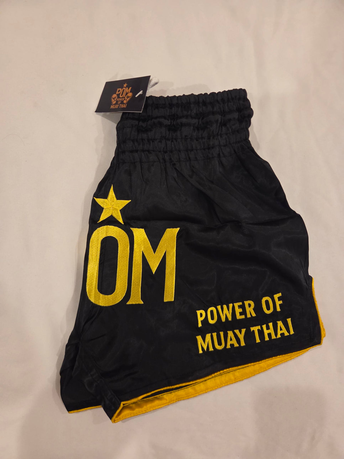 P.O.M Star Edition Shorts seitlich – Power of Muay Thai Stickerei und Goldsaum